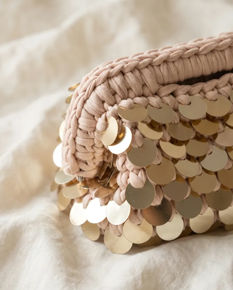 Dettaglio delle paillettes dorate sulla clutch cipria